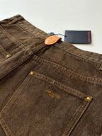 Brown denim pants with front pockets, stitched fly, and button closure