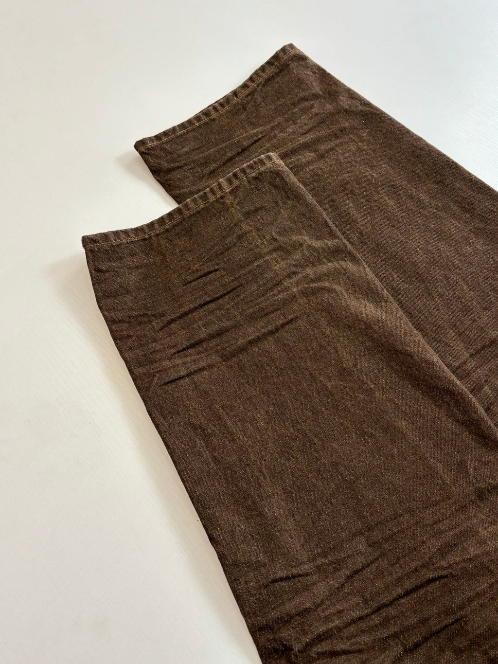 Louis Vuitton brown denim pants laid flat, visible front fly and stitching