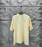 Balenciaga short-sleeve T-shirt, pale yellow crew neck with small chest logo.