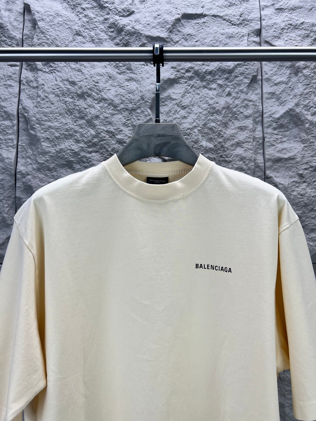 Cream short-sleeve T-shirt with BALENCIAGA logo at right chest, front view.