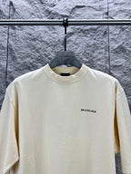 Cream short-sleeve T-shirt with BALENCIAGA logo at right chest, front view.