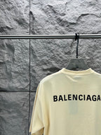 Cream short-sleeve T-shirt with large BALENCIAGA logo on upper back view.
