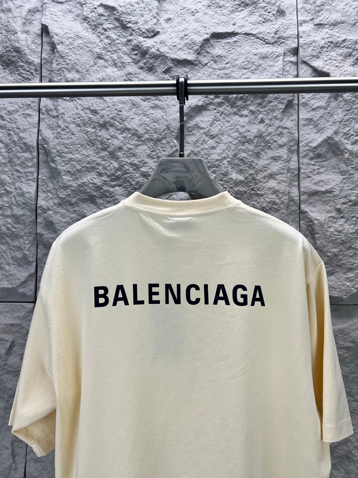 Cream short-sleeve T-shirt with large BALENCIAGA logo centered on upper back.