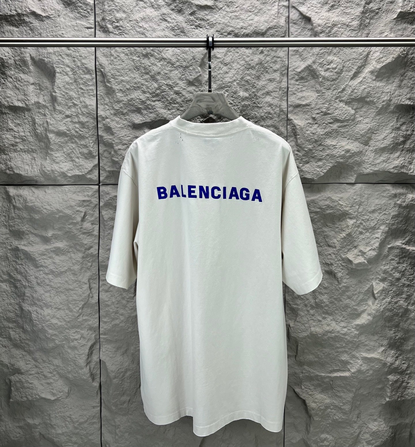 White crew-neck T-shirt with large blue Balenciaga logo on back