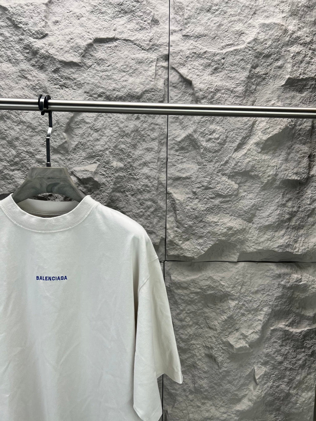 White crew-neck T-shirt with small blue Balenciaga logo on left chest