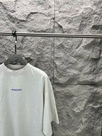 White crew-neck T-shirt with small blue Balenciaga logo on left chest