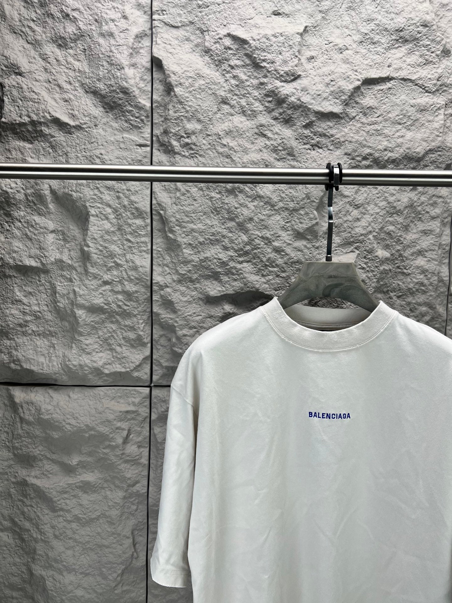 White crew-neck T-shirt with small Balenciaga logo on chest, close view