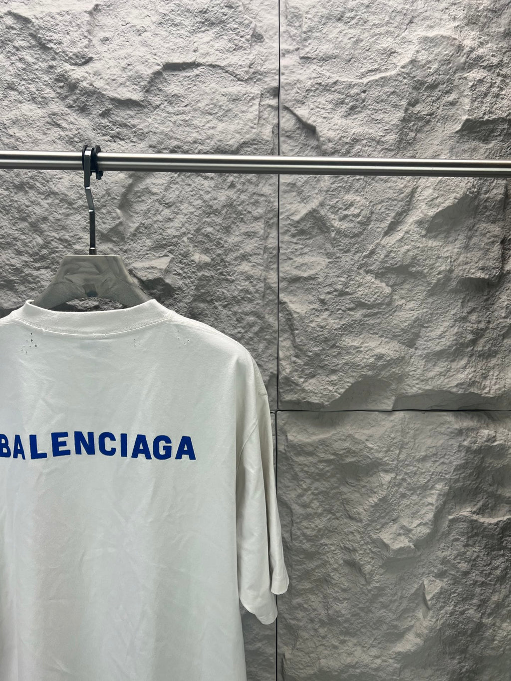 White crew-neck T-shirt with partial blue Balenciaga logo on back