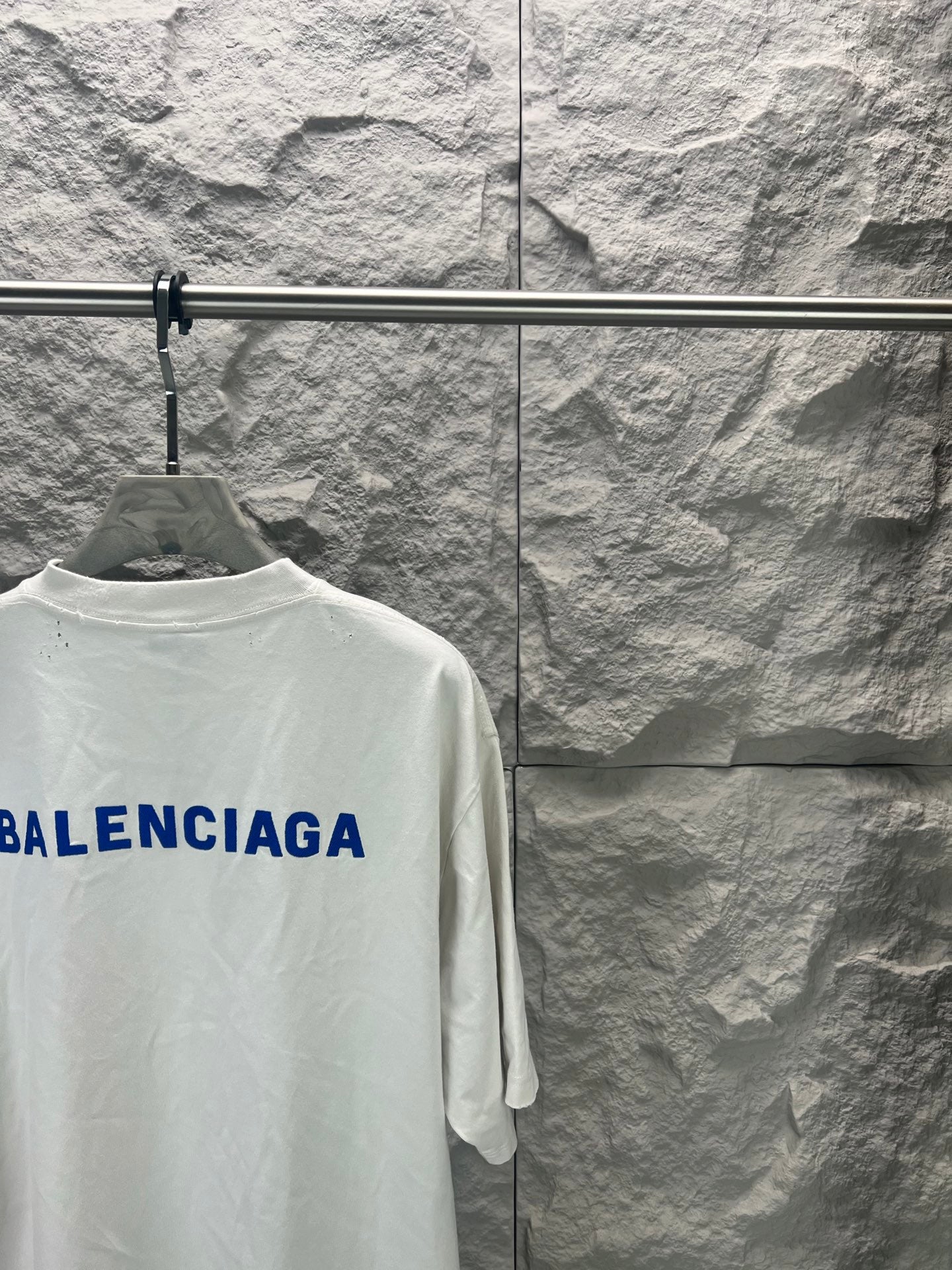 White crew-neck T-shirt with partial blue Balenciaga logo on back