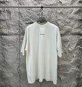 White crew-neck T-shirt on hanger with small Balenciaga logo on chest