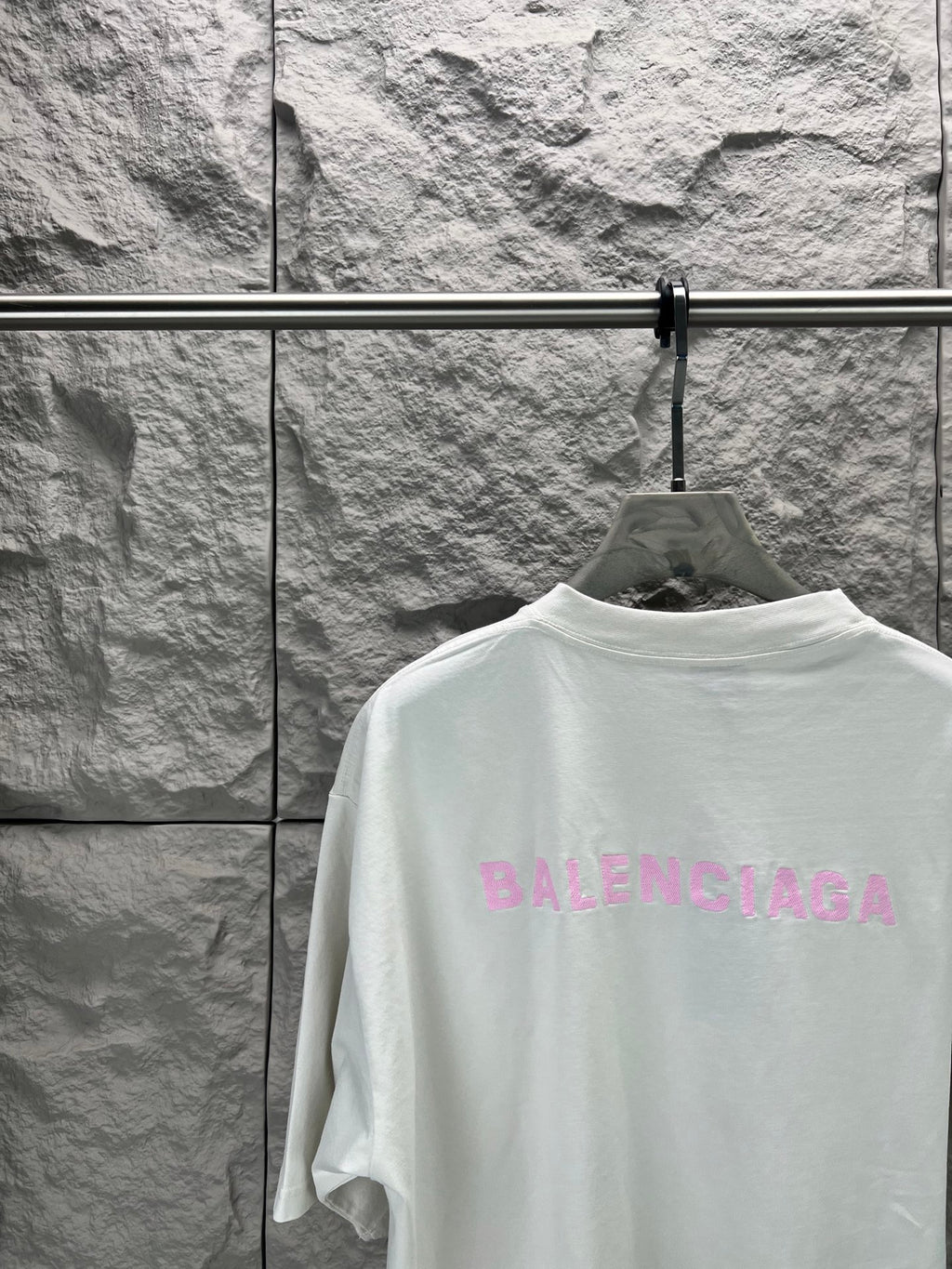 White T-shirt with large pink BALENCIAGA logo on back, close-up
