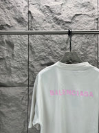 White T-shirt with large pink BALENCIAGA logo on back, close-up