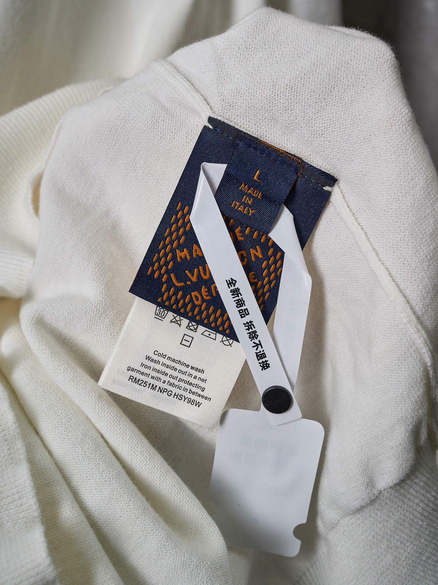 Light fabric short garment with attached Louis Vuitton clothing tag
