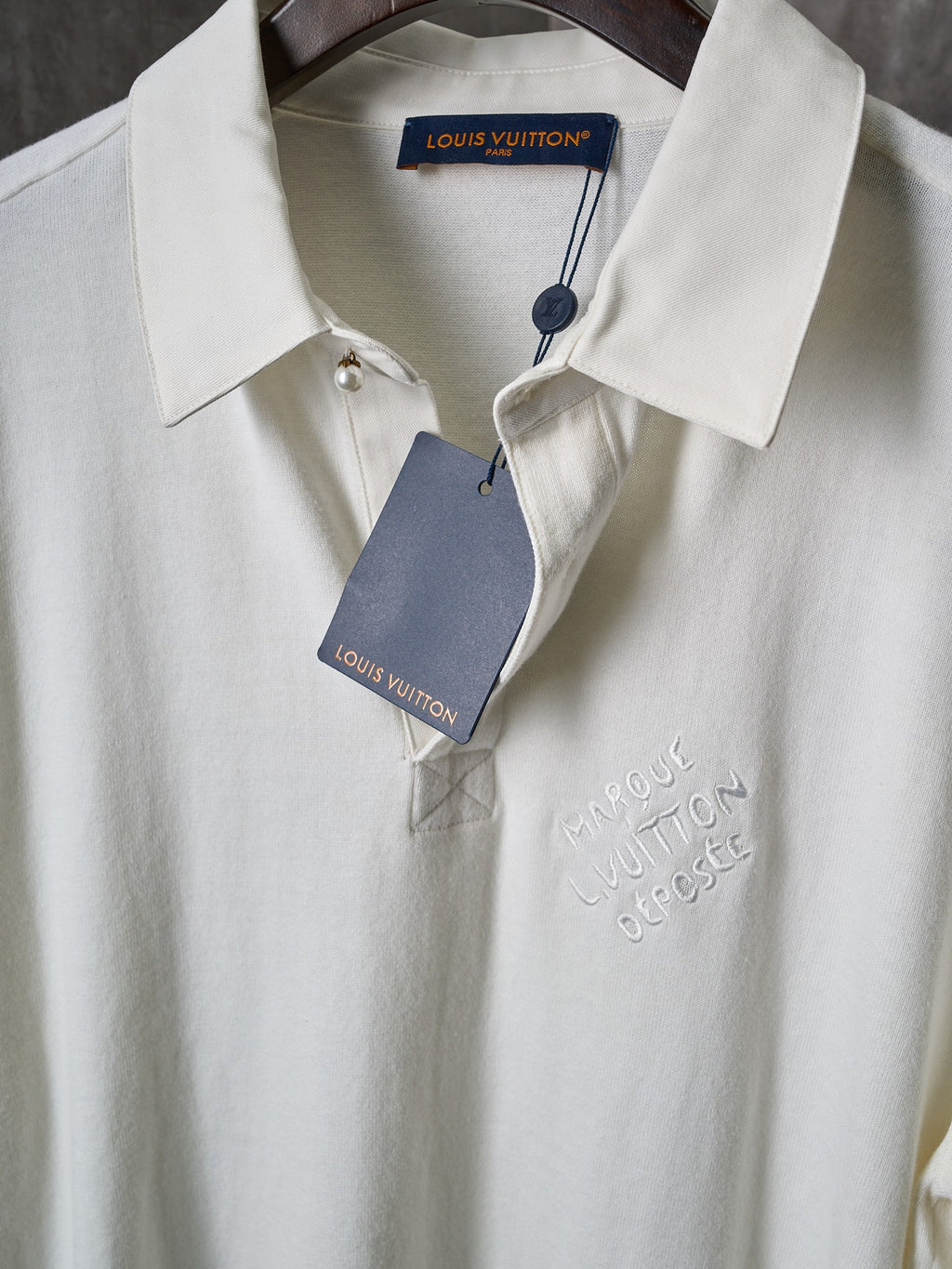 Louis Vuitton white polo shirt with button placket and brand tag at collar