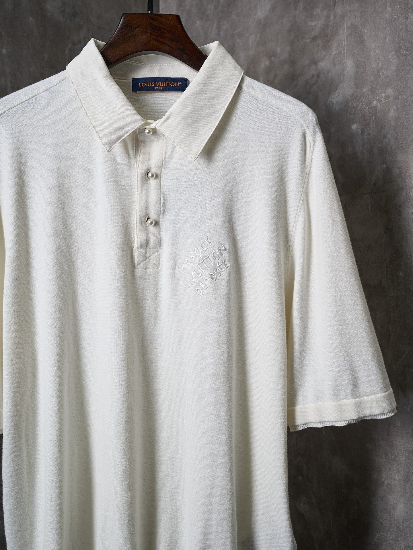 White polo shirt with three-button front and embroidered chest detail