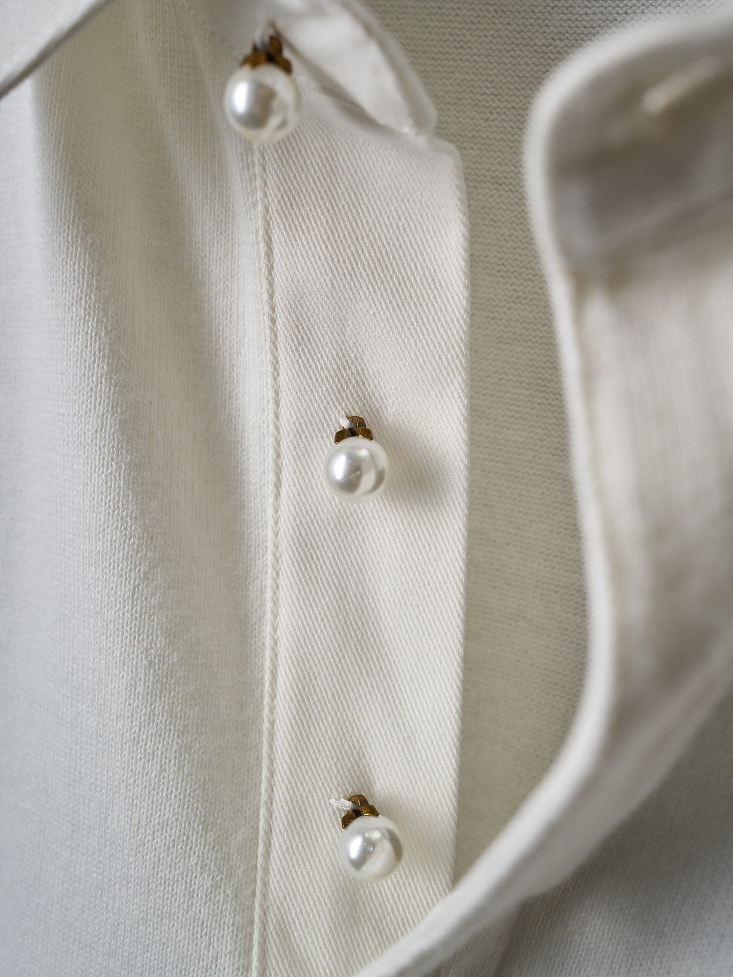 White polo shirt with pearl-look buttons on placket
