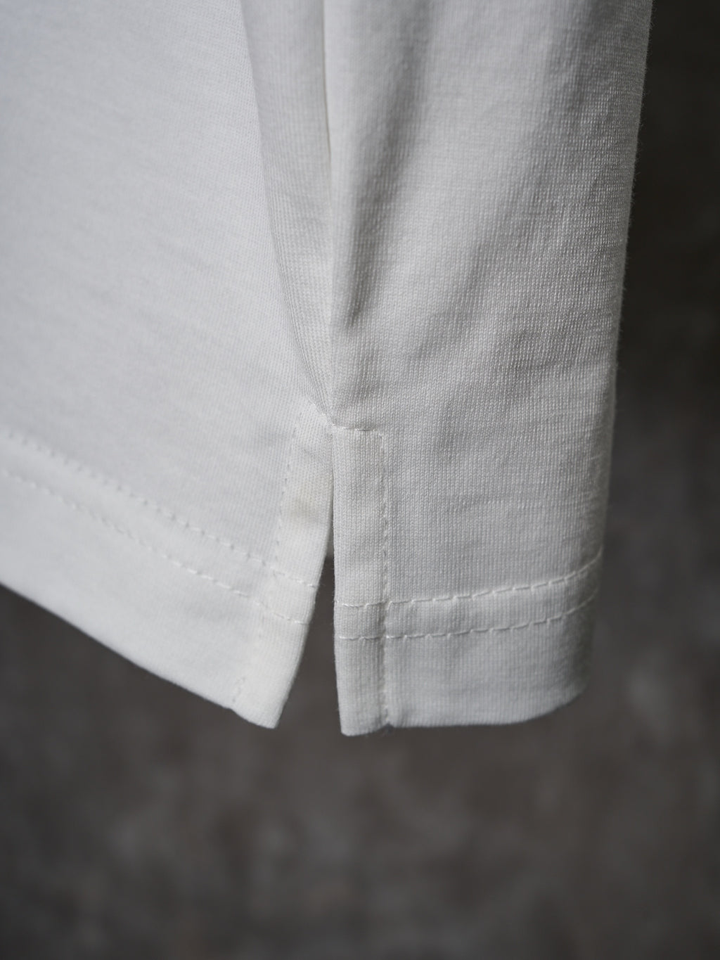 White T-shirt hem close-up with double-stitched seam