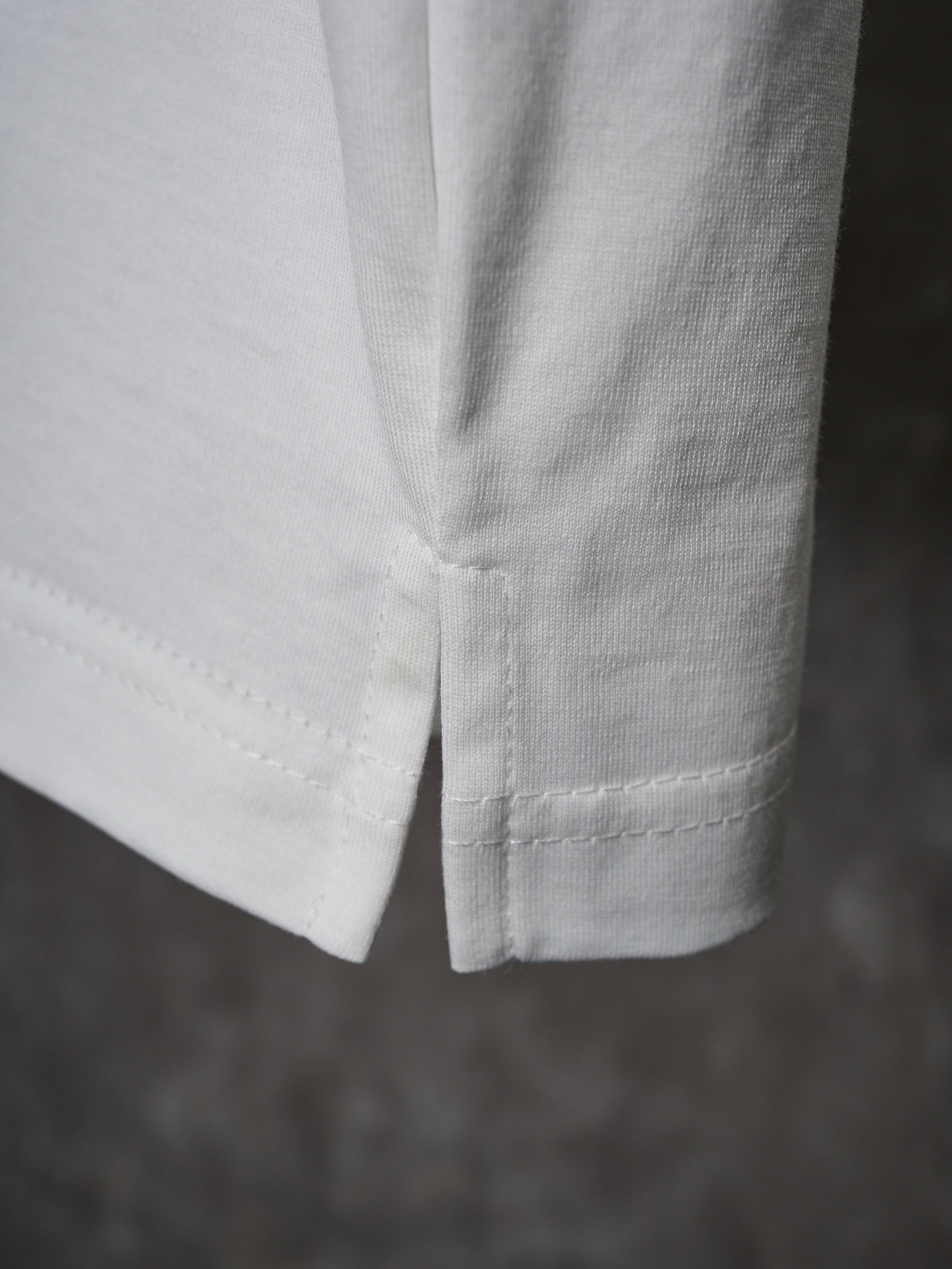 White T-shirt hem close-up with double-stitched seam