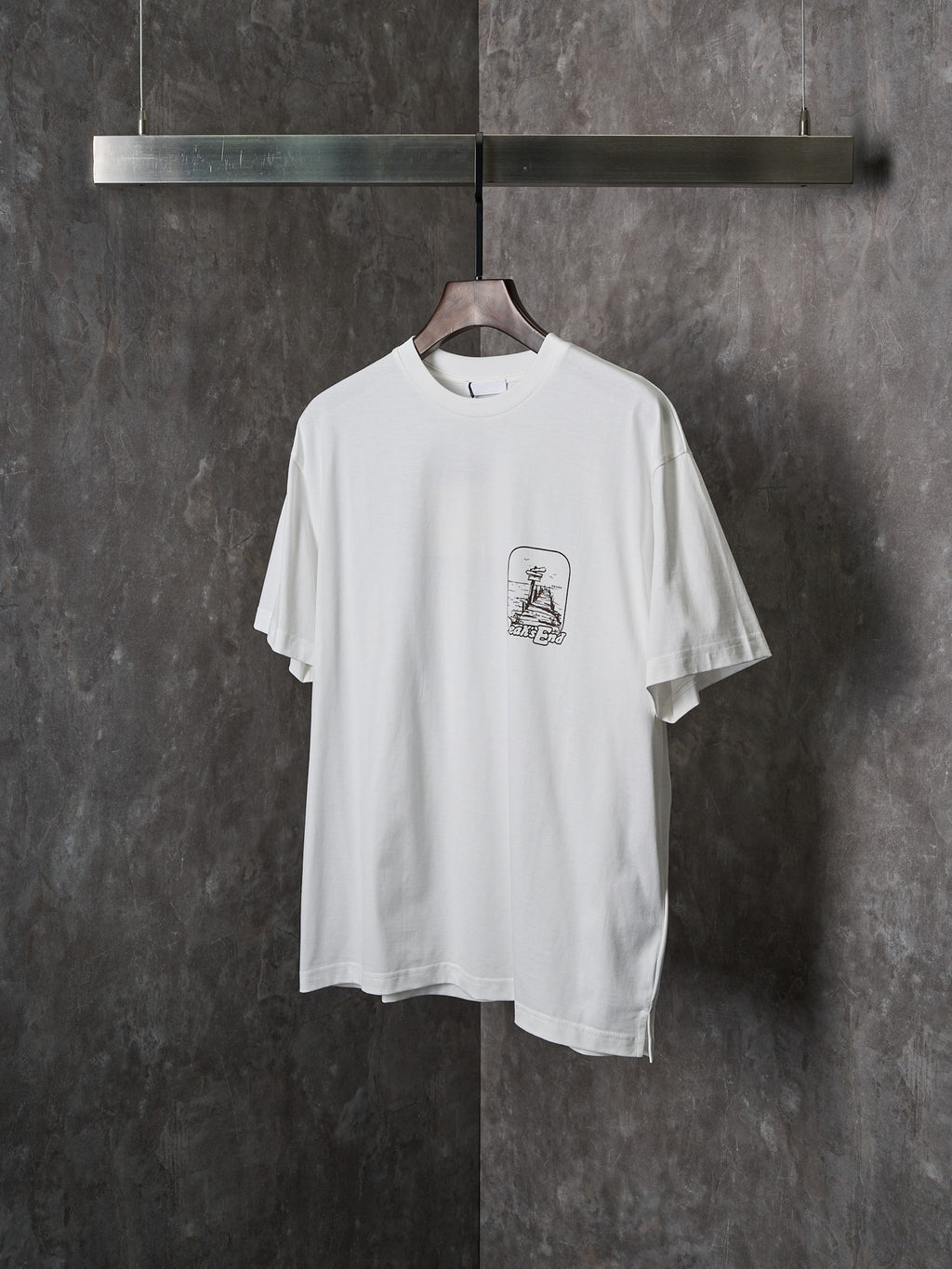 White short-sleeve T-shirt with front crest graphic, angled view