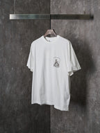White short-sleeve T-shirt with front crest graphic, angled view
