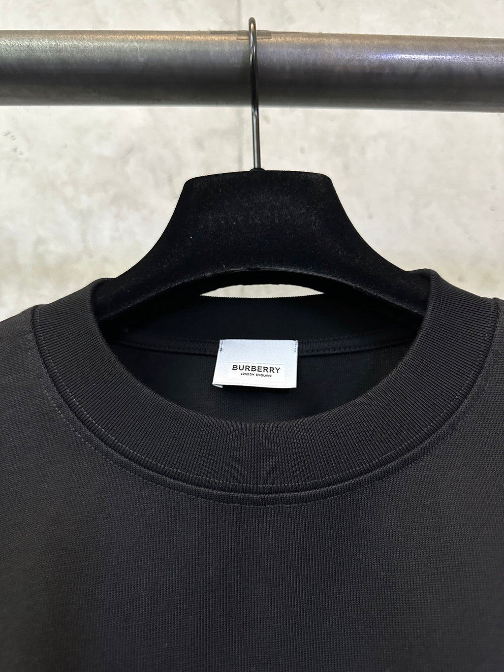 Black crew-neck T-shirt with ribbed collar and inner neck label