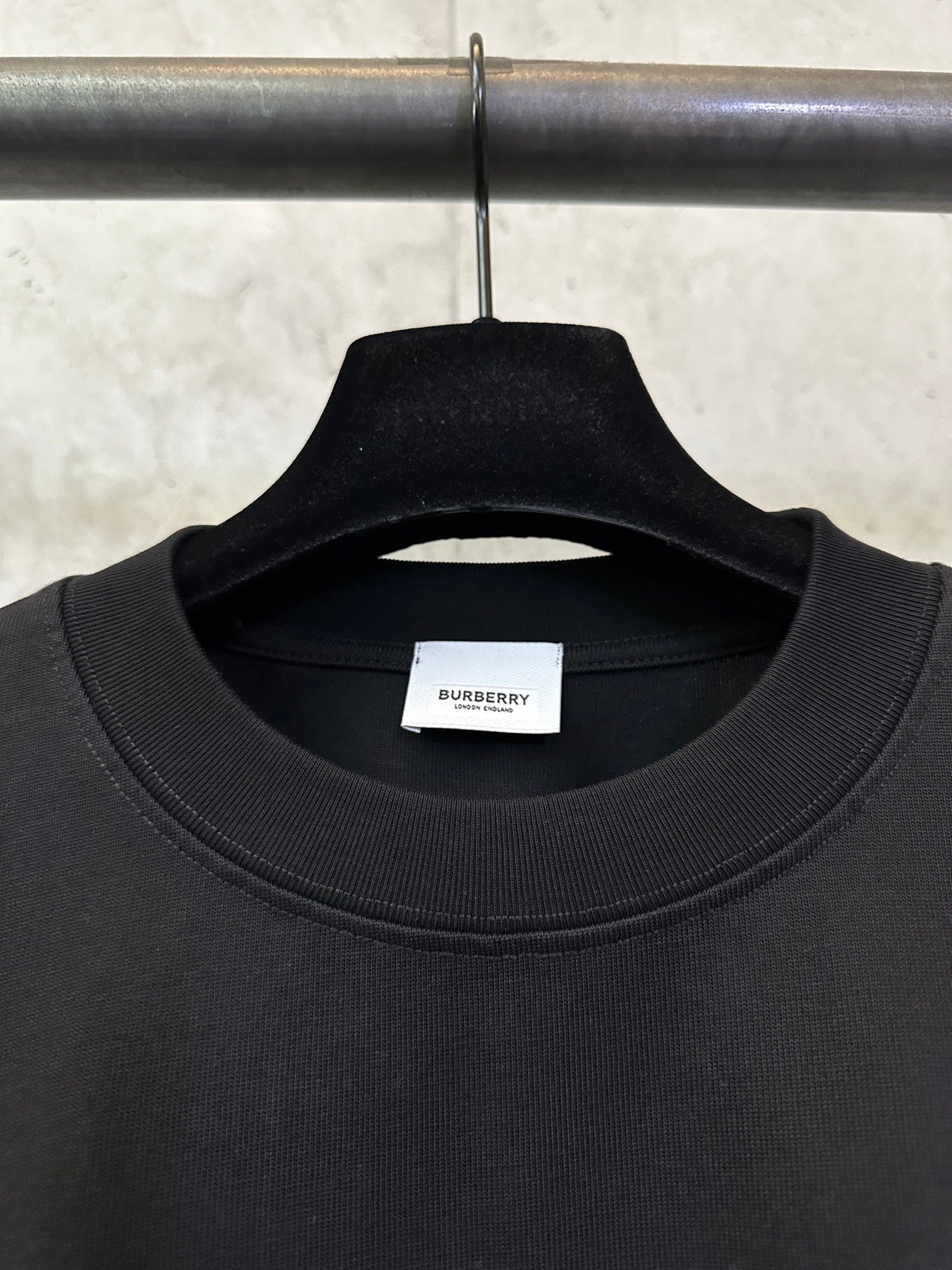 Black crew-neck T-shirt with ribbed collar and inner neck label