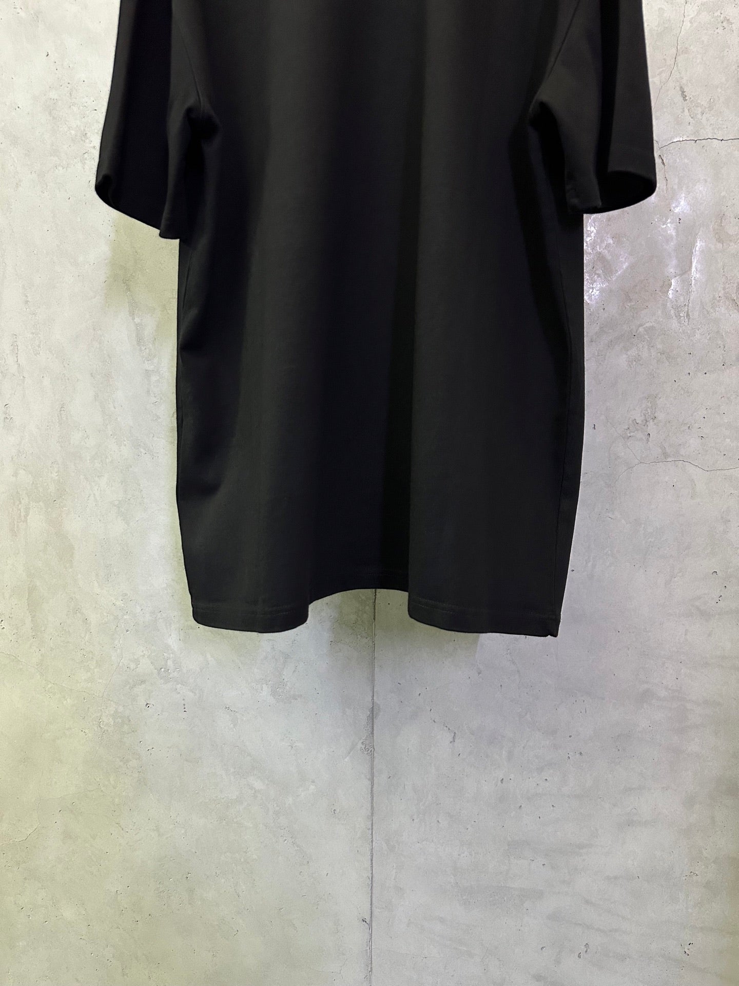 Black short-sleeve T-shirt, back lower hem view