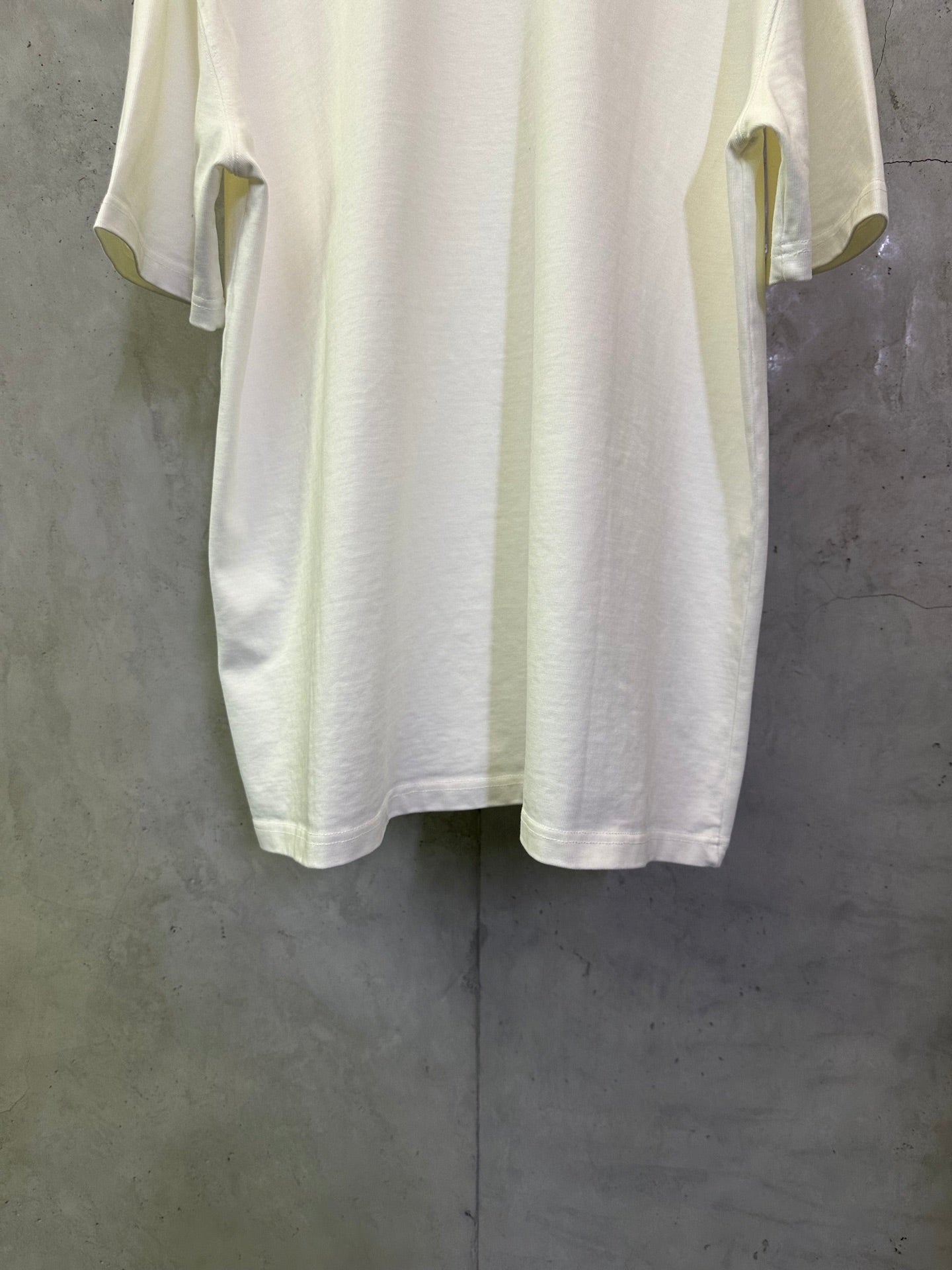 Off-white crewneck T-shirt back view with side sleeve openings and straight hem