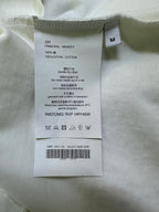 T-shirt size and care label showing “M” and cotton composition information