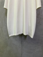 Off-white crewneck T-shirt with straight hem and short sleeves, laid flat for detail