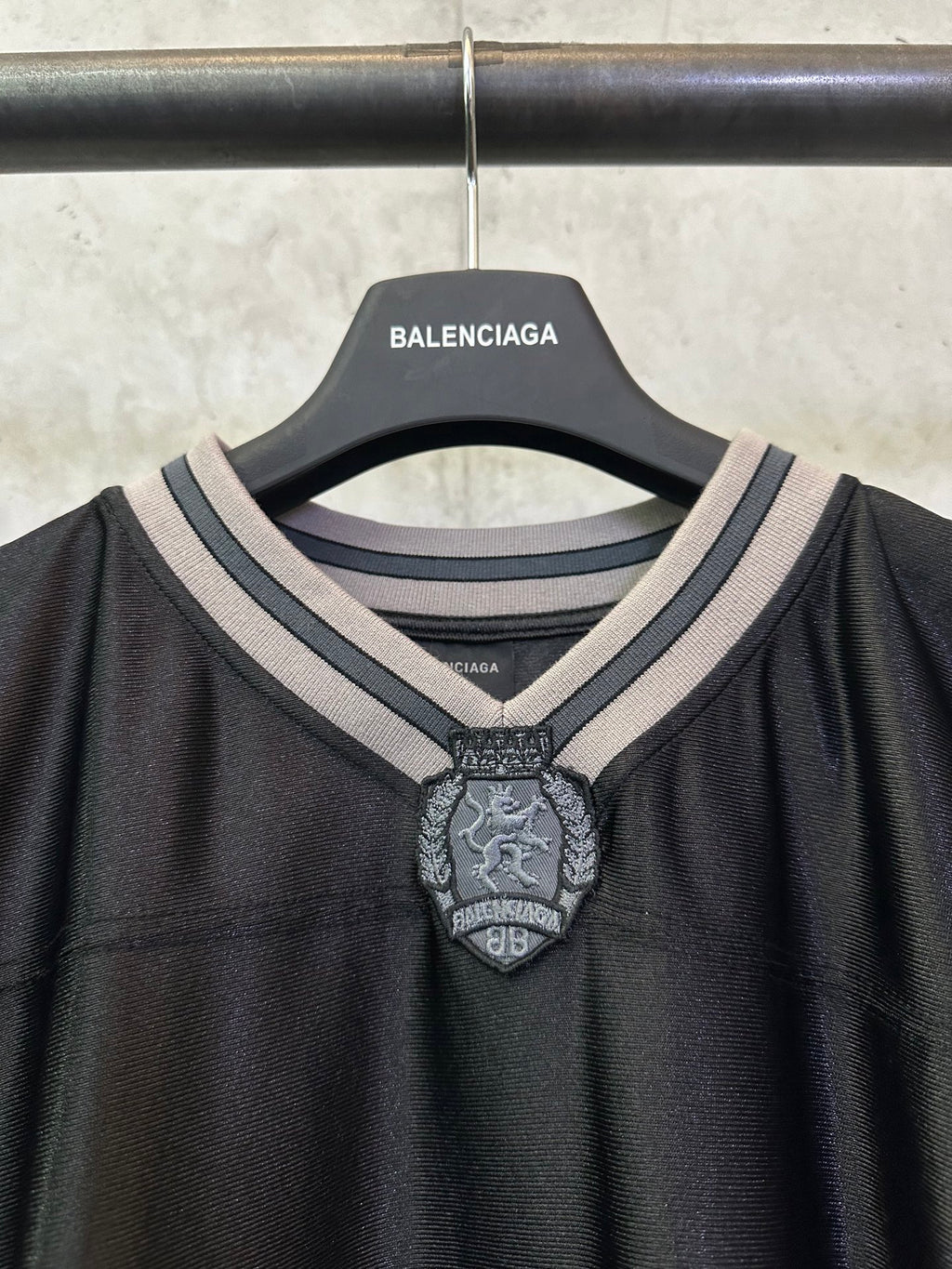 Balenciaga long-sleeve shirt neckline closeup with striped collar and crest badge