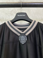 Balenciaga long-sleeve shirt neckline closeup with striped collar and crest badge