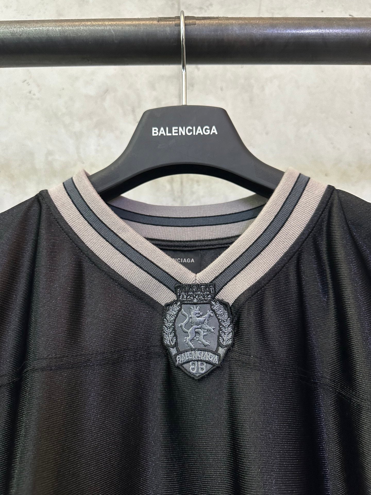 Balenciaga long-sleeve shirt neckline closeup with striped collar and crest badge