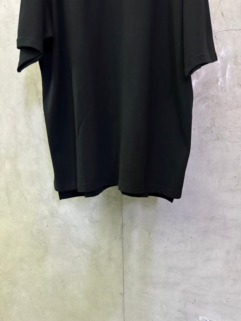 Balenciaga black polo shirt, lower front view with straight hem and short sleeves