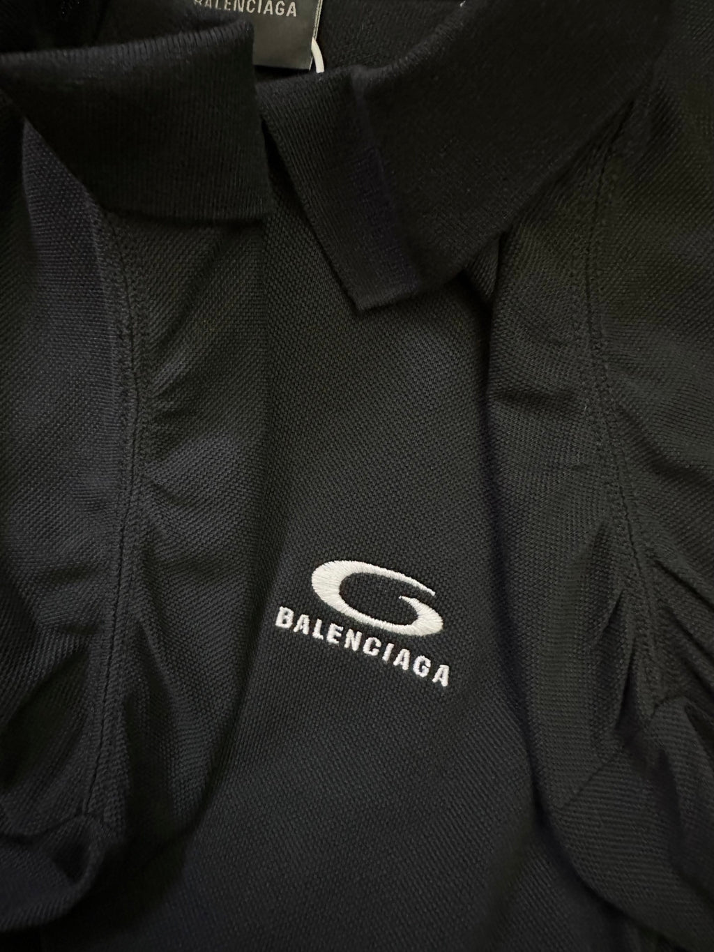 Balenciaga polo shirt fabric close-up with embroidered oval logo on chest