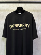 Black Burberry short-sleeve T-shirt with yellow 'BURBERRY' and 'LONDON ENGLAND'