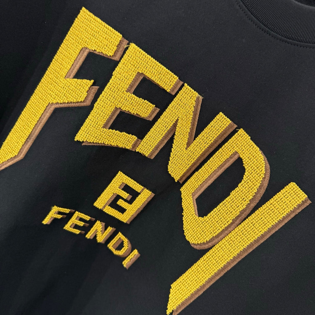 Black short-sleeve T-shirt close-up: yellow FENDI logo and FENDI E mark