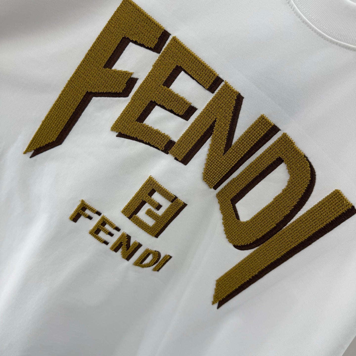 Fendi white short-sleeve T-shirt close-up of gold FENDI logo print