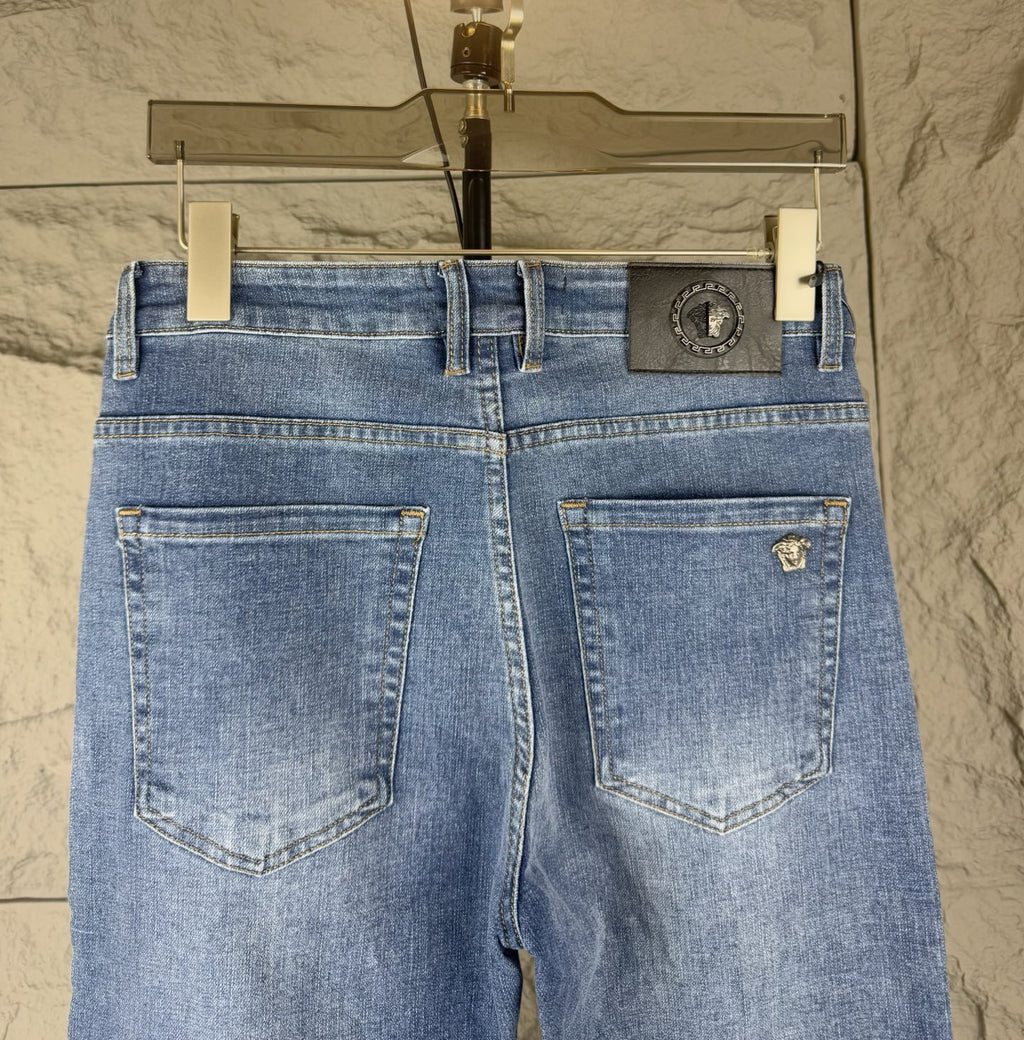 Versace blue denim jeans back view with stitched pockets and central waistband logo patch
