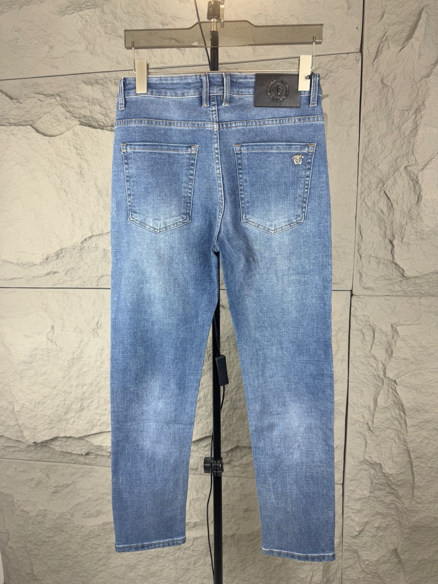 Versace light blue denim jeans front view, belt loops and stitched front pockets