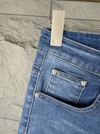 Versace blue denim jeans close-up of front pocket and coin logo patch on waistband