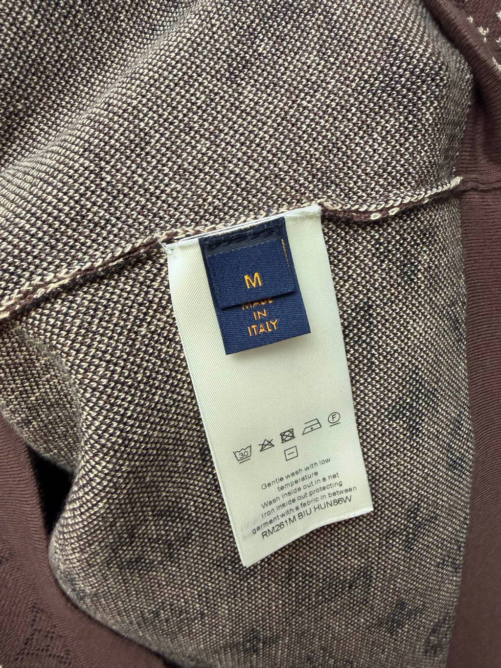 Clothing label close-up on short-sleeve T-shirt fabric, size tag and logo text