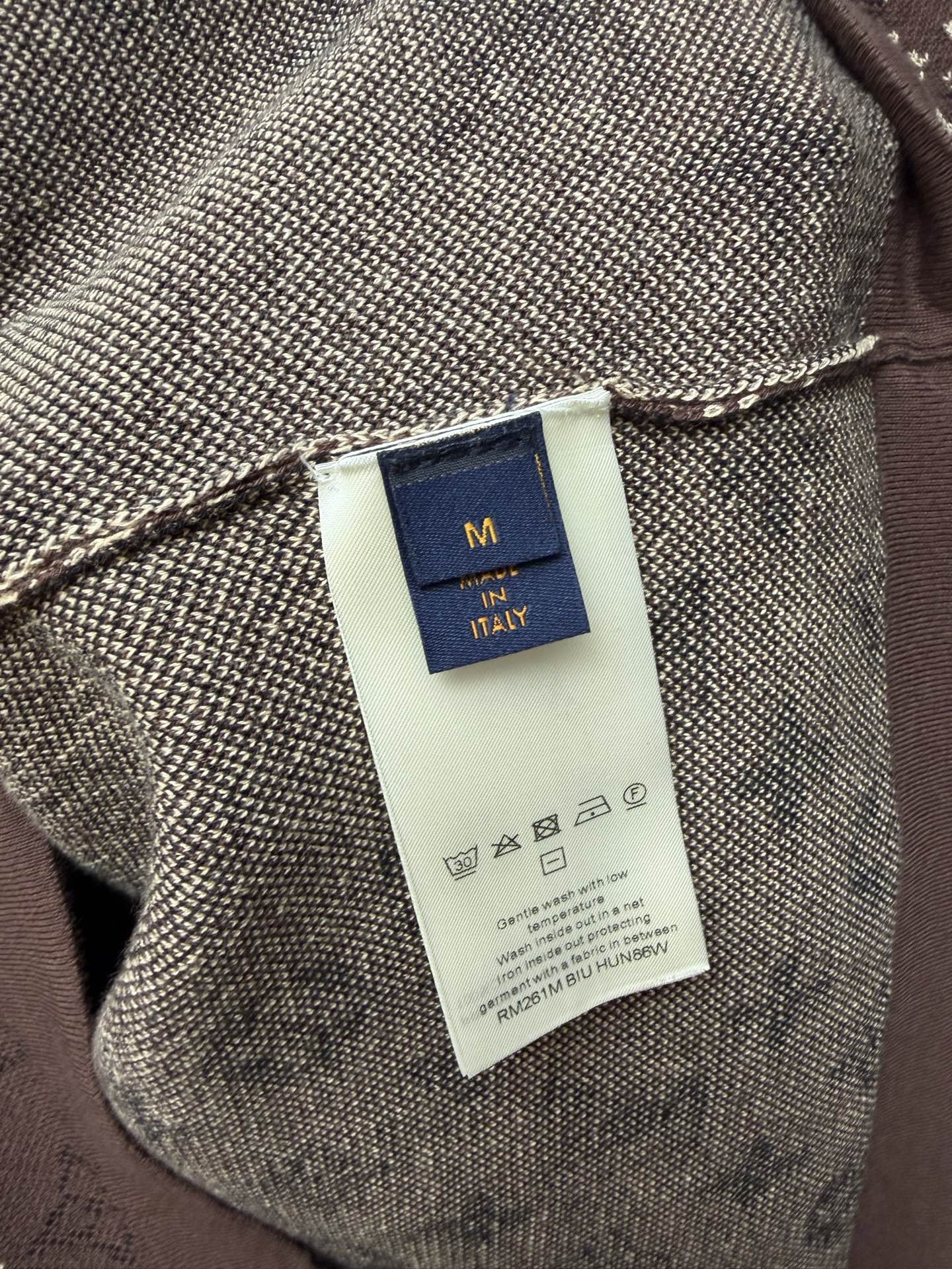 Clothing label close-up on short-sleeve T-shirt fabric, size tag and logo text