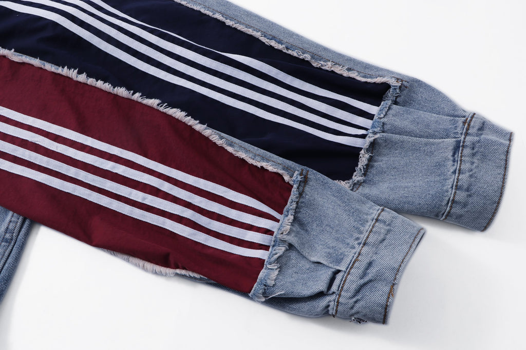Denim jacket sleeve detail with maroon panel and white striped trim