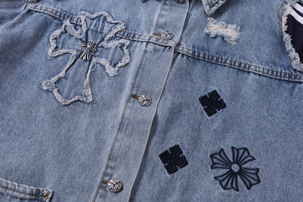 Denim jacket front detail with cross patch, black flower motifs, and buttons