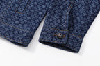 Dark blue patterned shirt cuff with decorative button and stitched seam