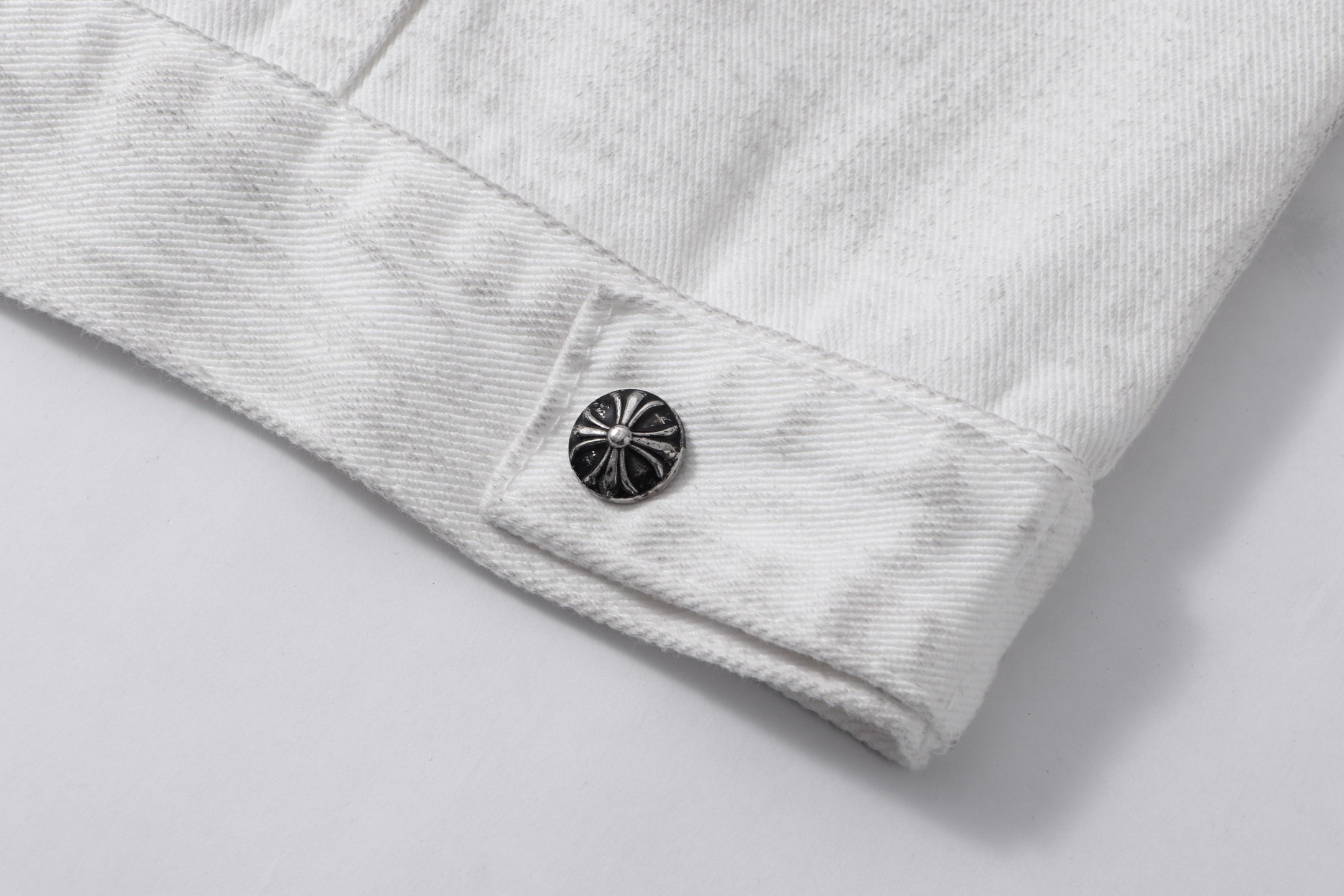 White denim jacket lower sleeve or hem with dark round button