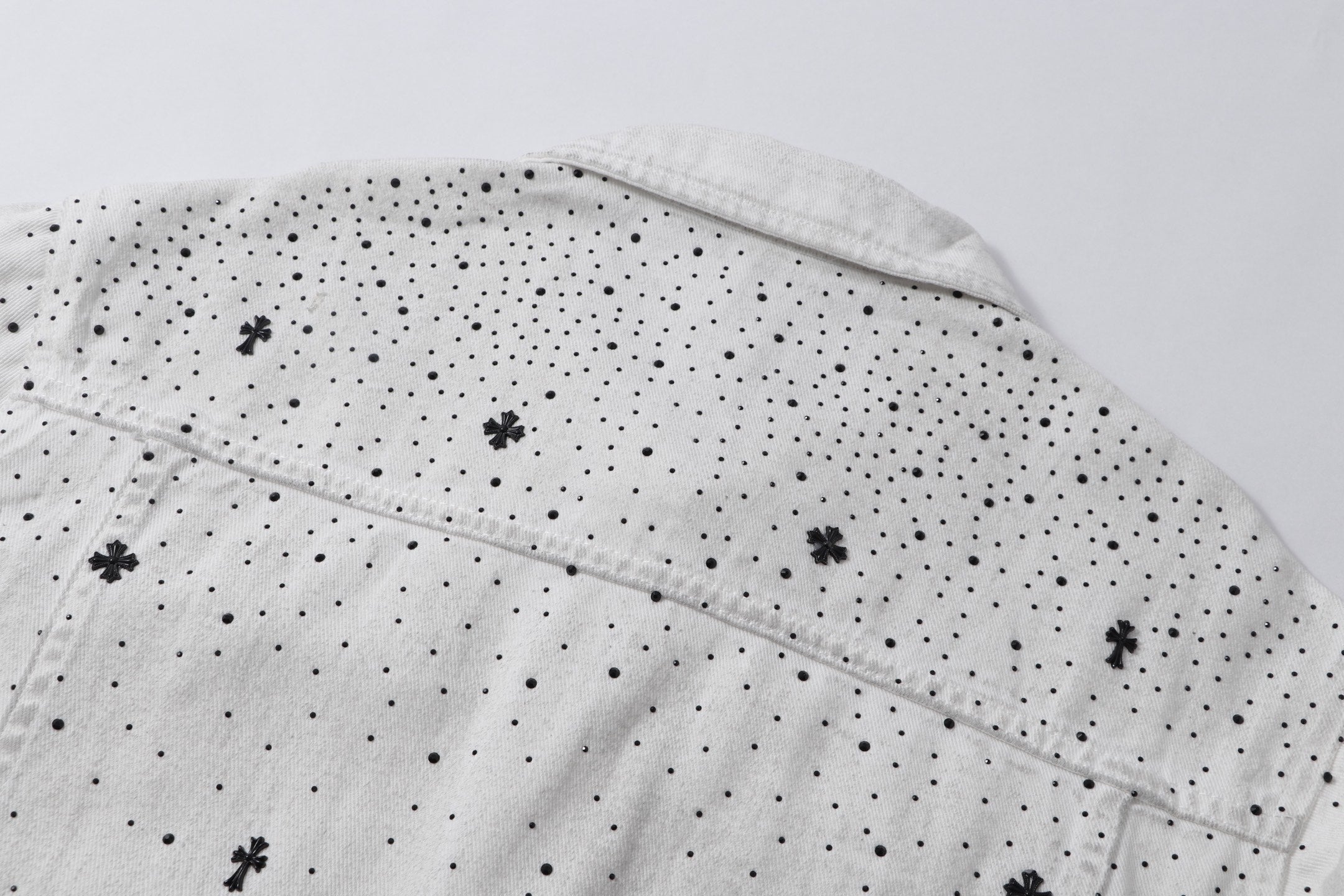 White denim jacket back yoke with embroidered cross and dot pattern
