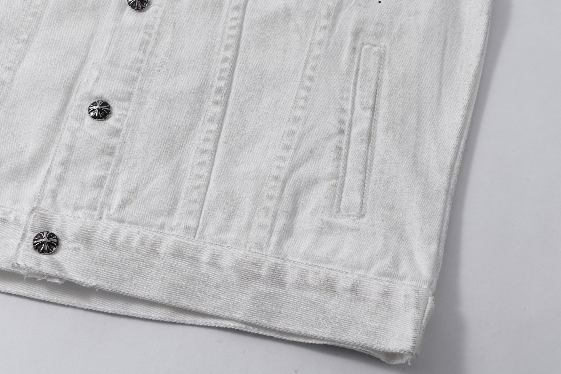 White denim jacket lower front with button row and vertical stitching details