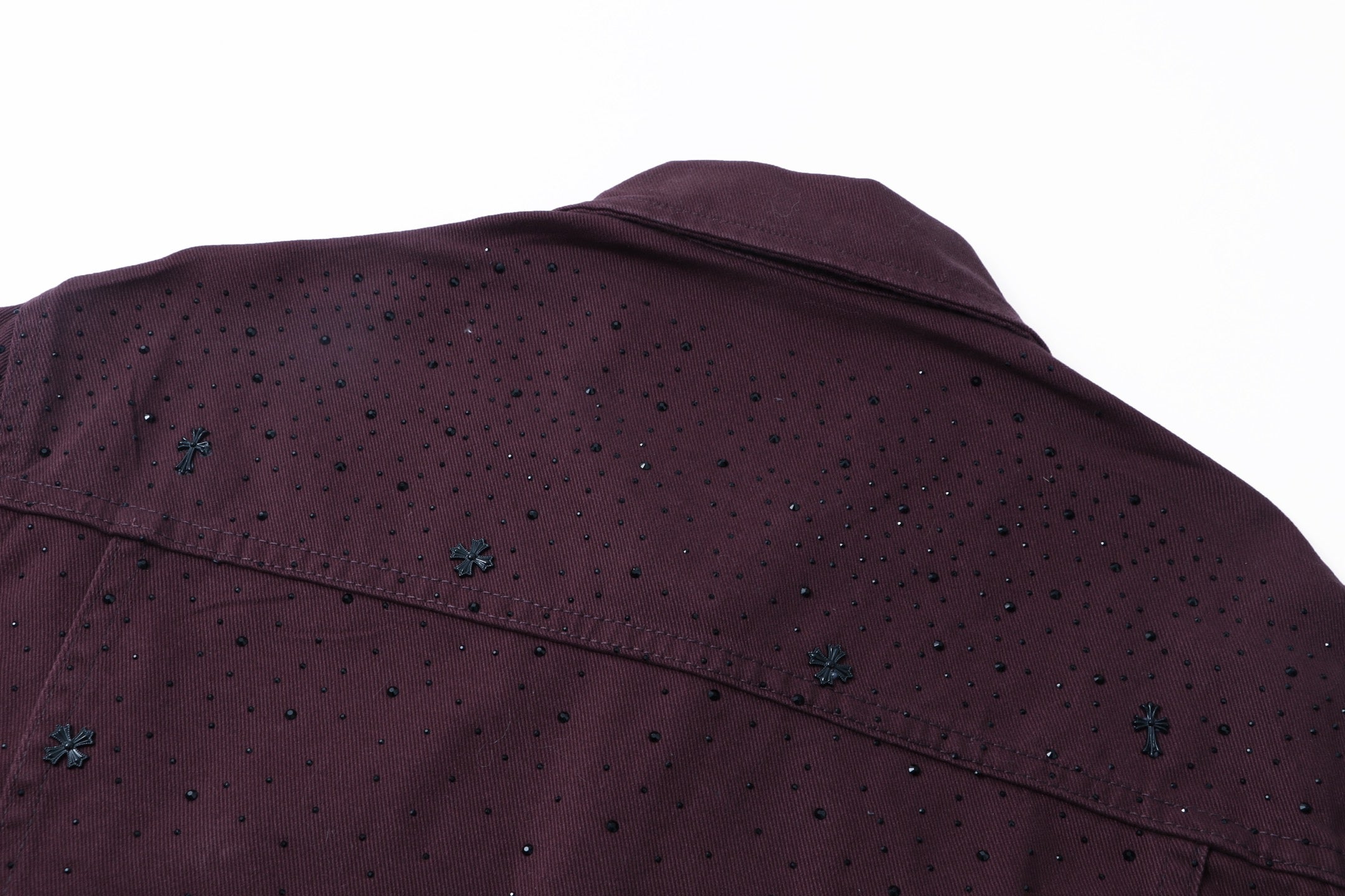 Shoulder and upper back detail on dark plum long-sleeve jacket with speckle embroidery